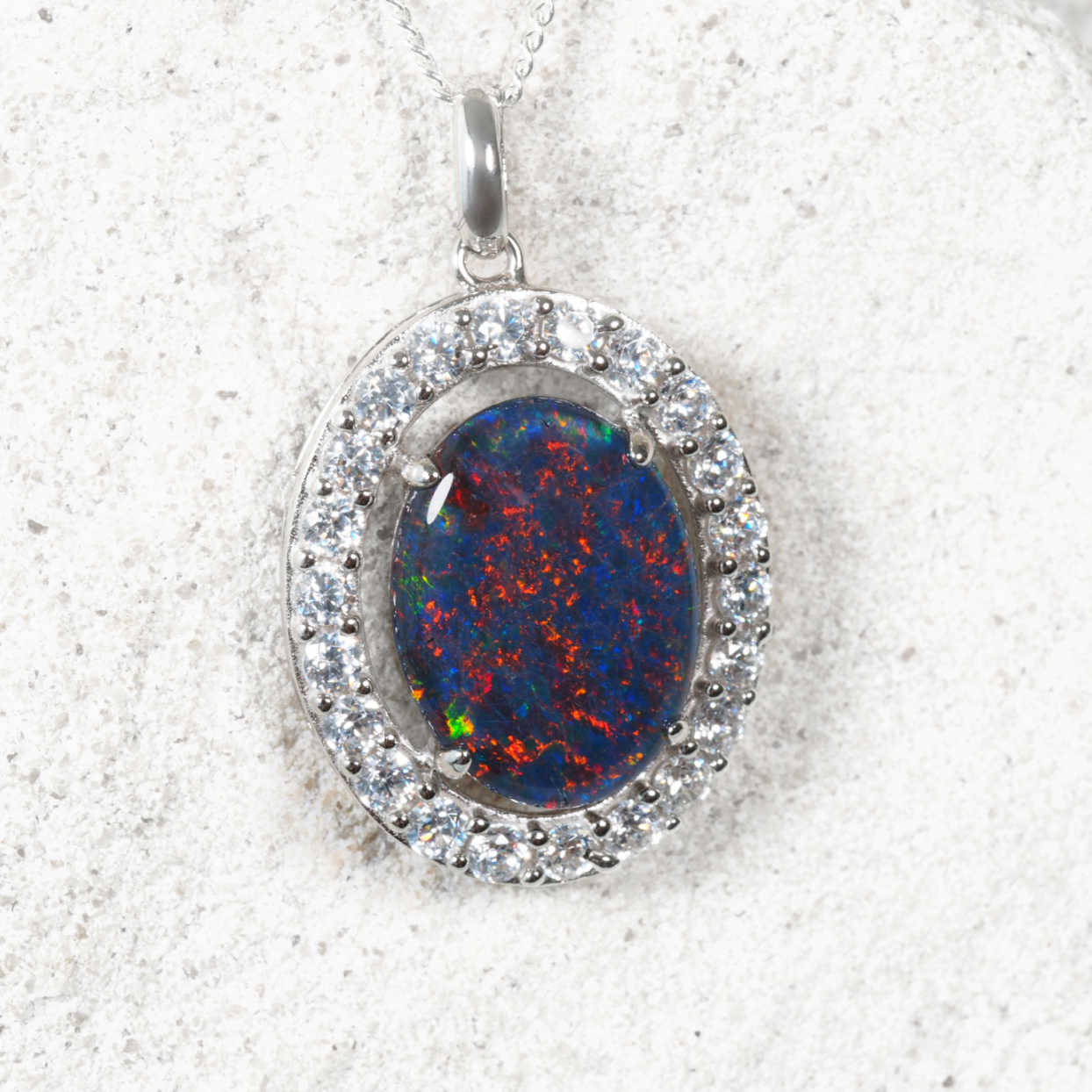 sterling silver opal pendant with oval Australian triplet opal surrounded by twenty-two cubic zirconias