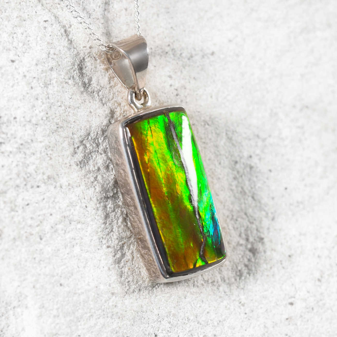 Close-up of 'Taylah' pendant highlighting the luminous Ammolite gemstone in a sleek silver frame