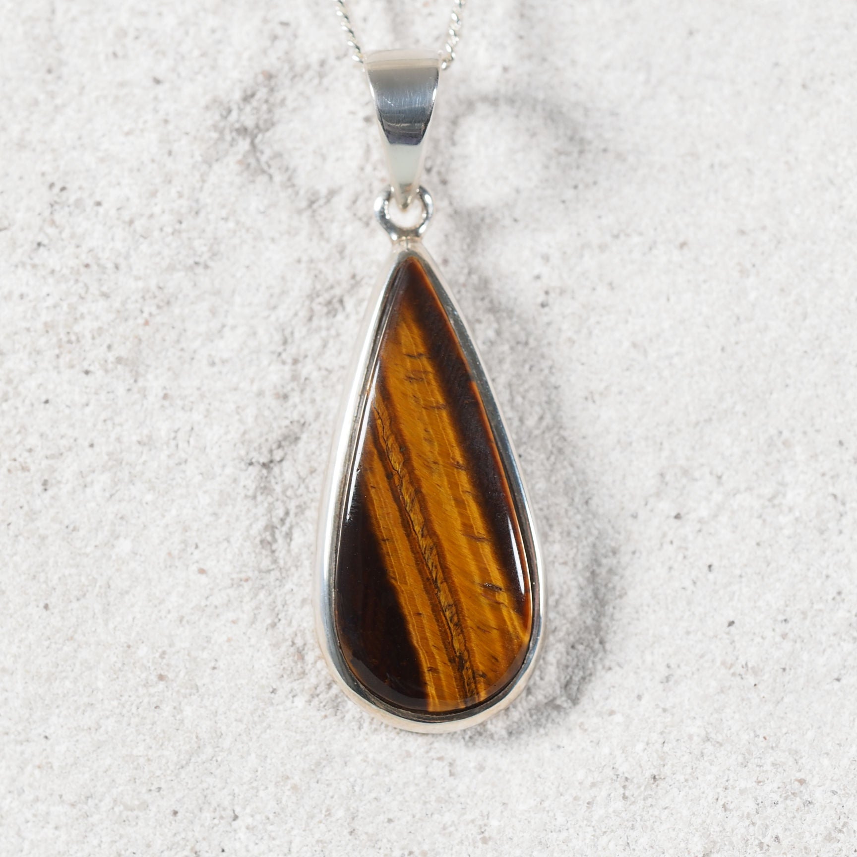 Brown Tiger’s Eye pendant showcasing refined bezel setting and natural silky sheen