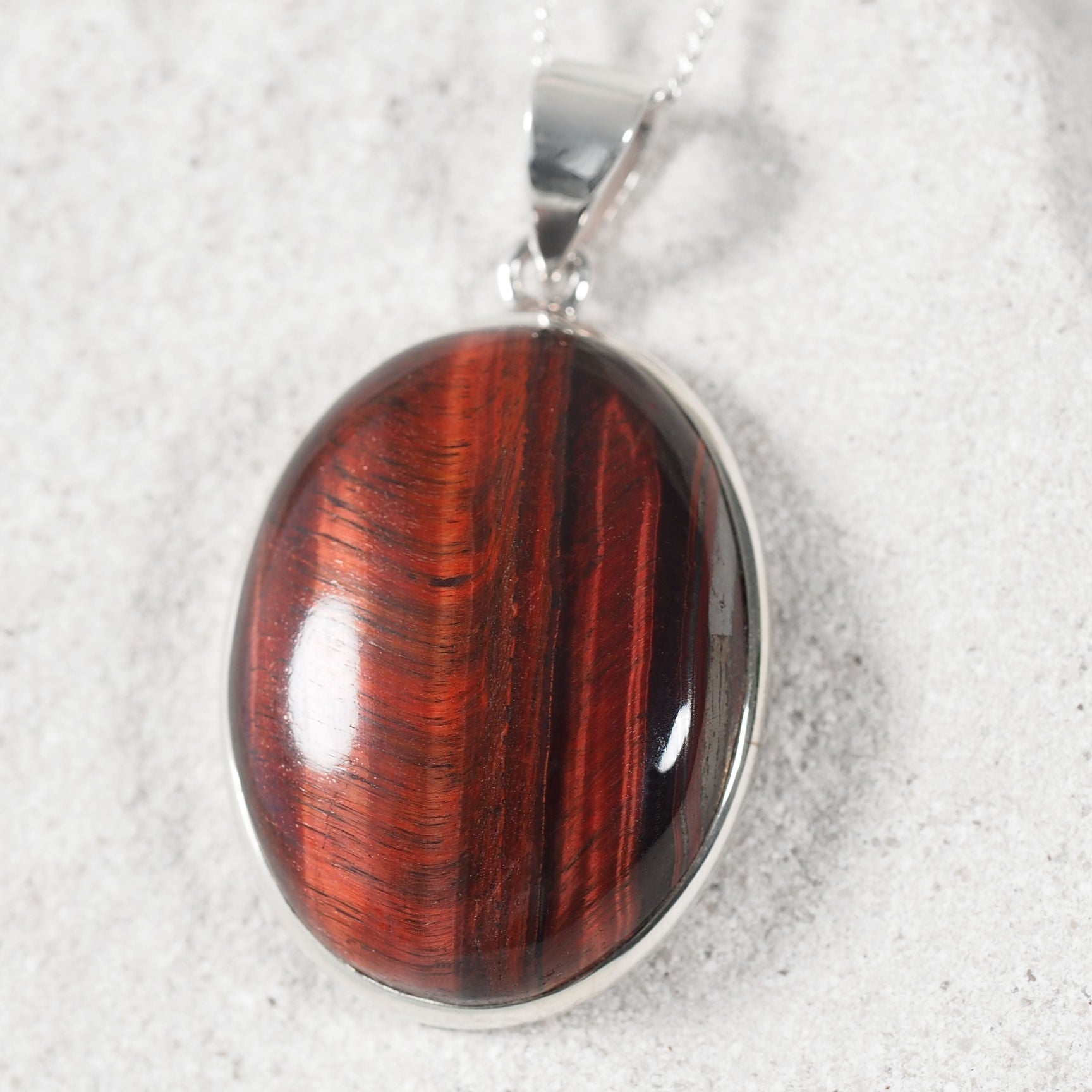 Sterling silver pendant with circular Red Tiger Eye gemstone showing deep reddish-brown tones