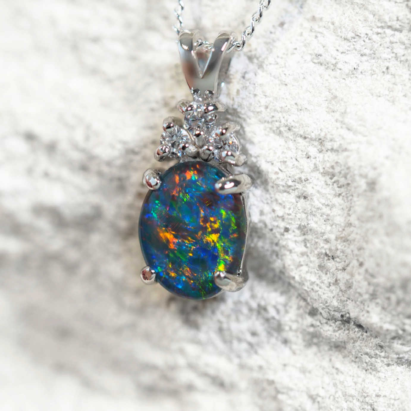 Elegant sterling silver necklace pendant featuring multi-coloured Australian triplet opal topped with three cubic zirconias