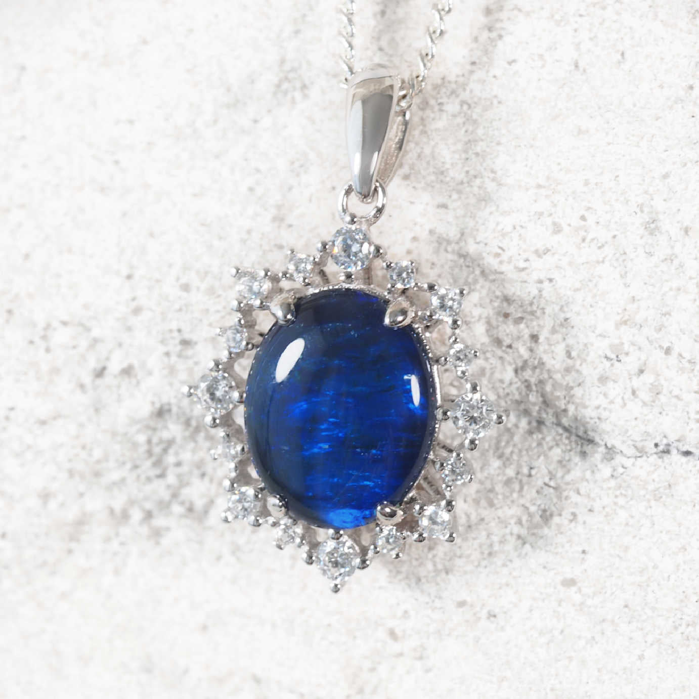 Elegant sterling silver opal necklace pendant featuring oval blue Australian triplet opal surrounded by 16 cubic zirconias