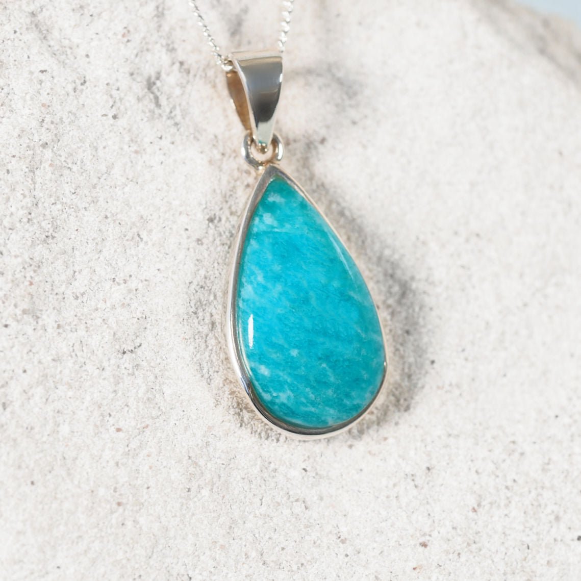 'Yvonne' pendant showcasing a smooth Amazonite gemstone in blue-green shades, set in a sleek silver bezel