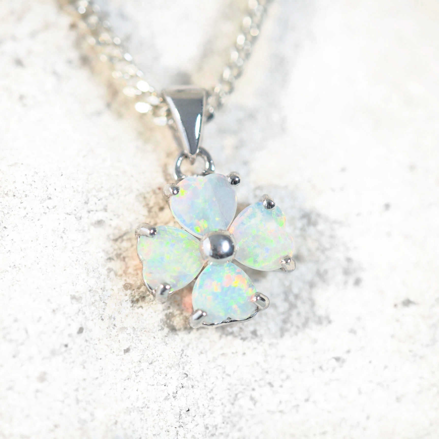 blue and green opal pendant set in silver with a flower design
