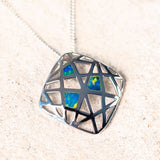 blue and green doublet opal set into a silver cage pendant