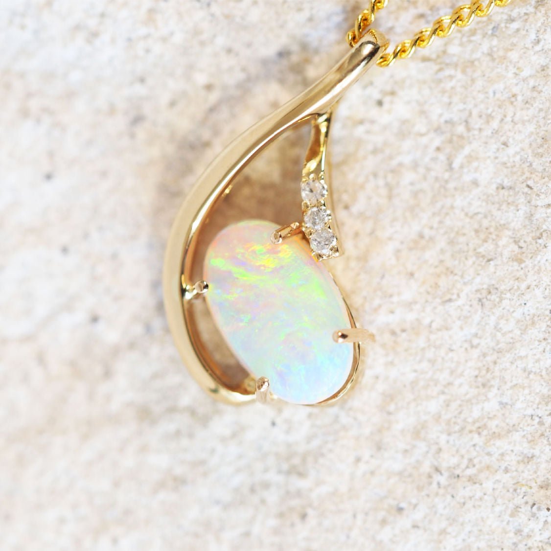 diamond and opal gold pendant set with three diamonds