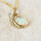 multi-colour crystal opal set with three diamonds set in a gold pendant