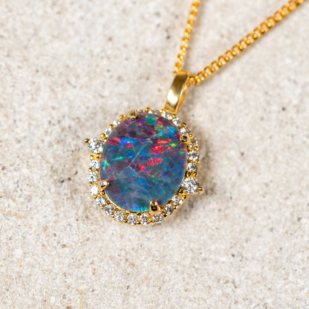 gold plated sterling silver necklace pendant claw set with a multi-coloured round-oval Australian triplet opal surrounded by 24 cubic zirconias