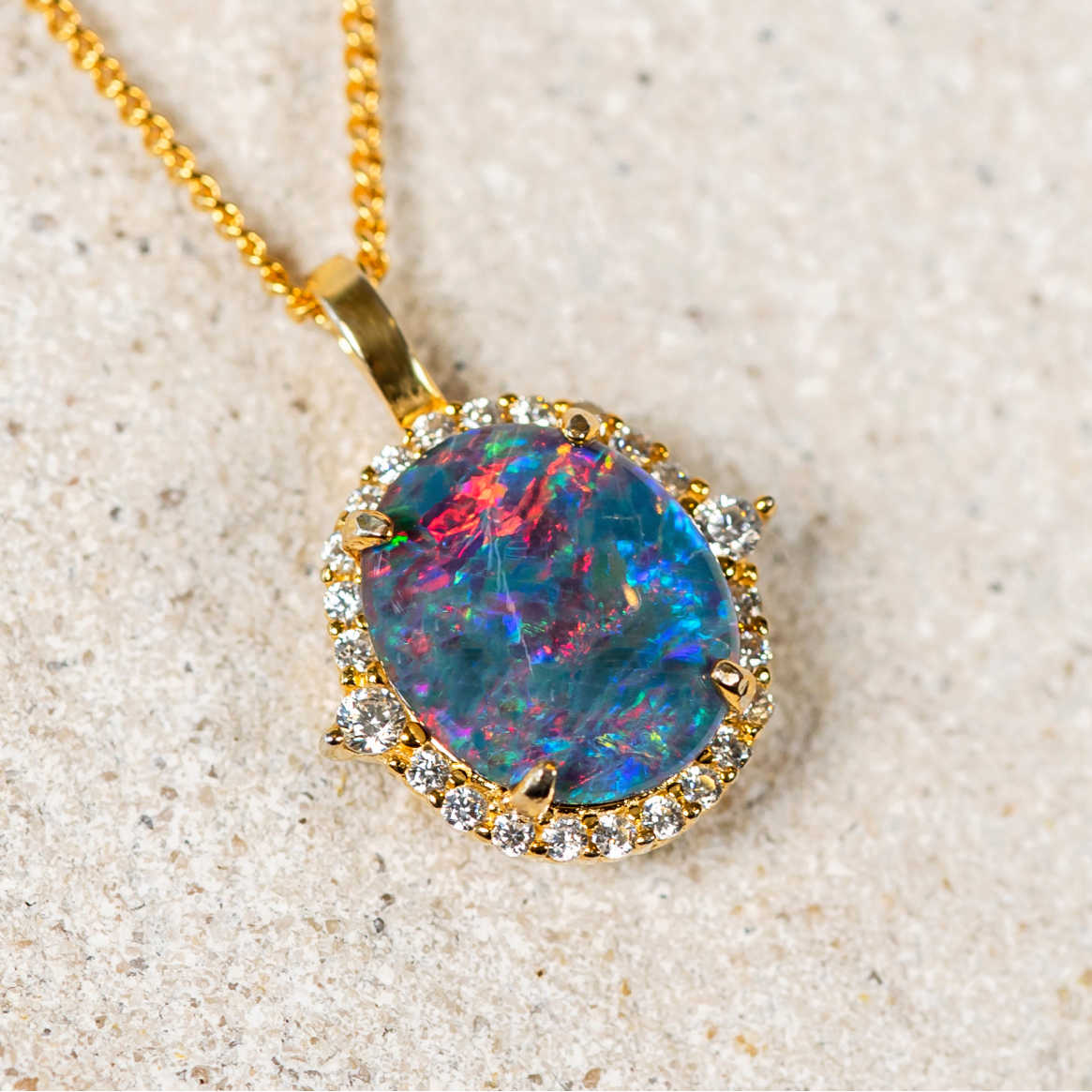 Sparkling gold plated sterling silver necklace pendant with a multi-coloured Australian triplet opal surrounded by a halo of 24 cubic zirconias.