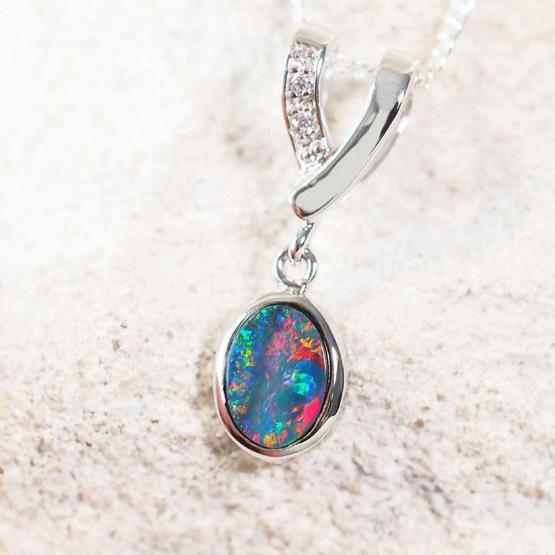colourful oval australian opal set into a silver necklace pendant 