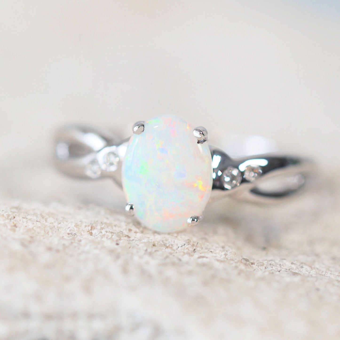 colourful white opal engagement ring set in white gold with four diamonds