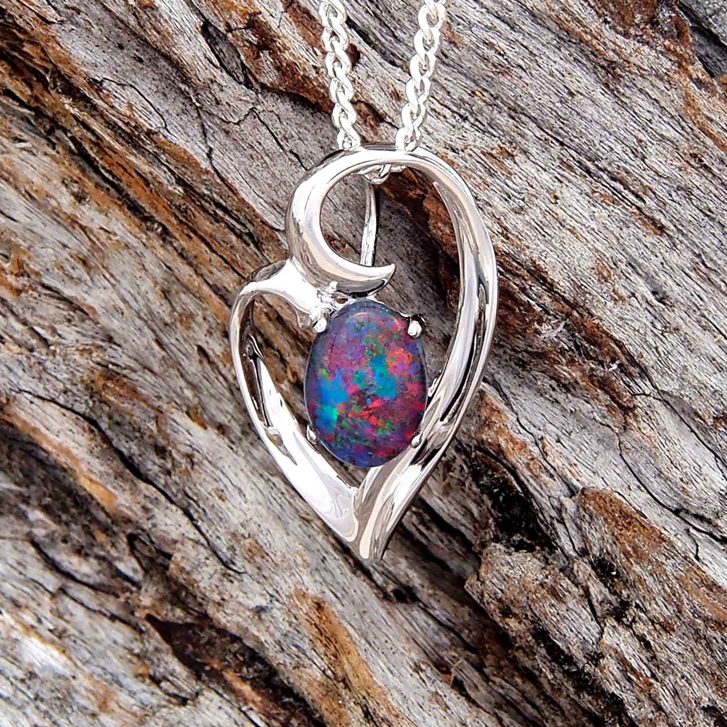 Stylish sterling silver heart style necklace pendant claw set with a blue, green and red oval triplet opal.