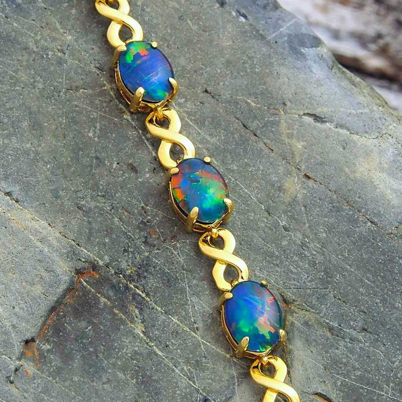 Gold plated sterling silver figure-8 design bracelet claw-set with five beautiful multi-colour oval triplet opals