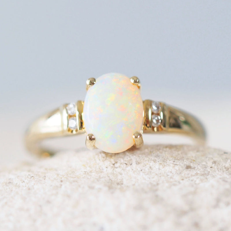 colourful white opal oval ring set with 14ct gold and four diamonds