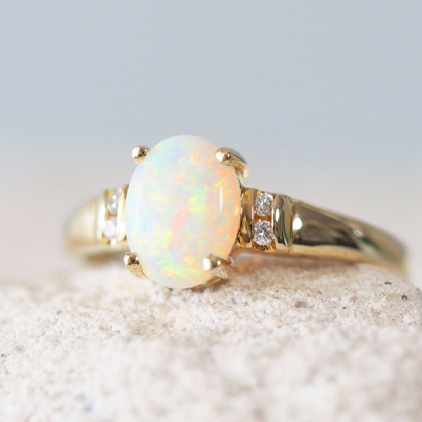 colourful white opal gold ring set with four sparkling diamonds