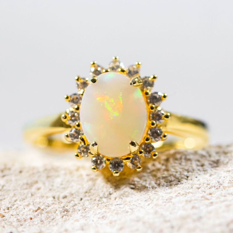 colourful oval white opal set in a gold plated silver princess design ring surrounded by 16 crystals