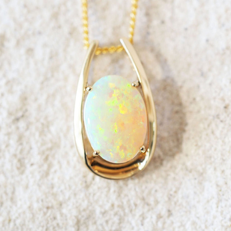 colourful oval crystal opal set into a gold pendant