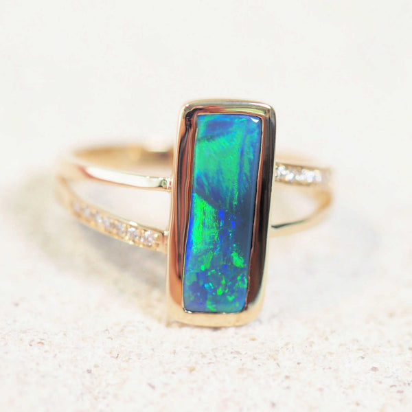 black opal gold ring featuring blue and green colours set with 14 sparkling white diamonds